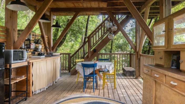 Eine Küche mit einem Tisch und Stühlen auf einem Deck