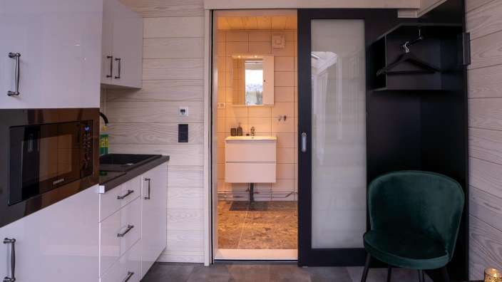 Eine Küche mit einem Mikrowellenherd und einem grünen Stuhl