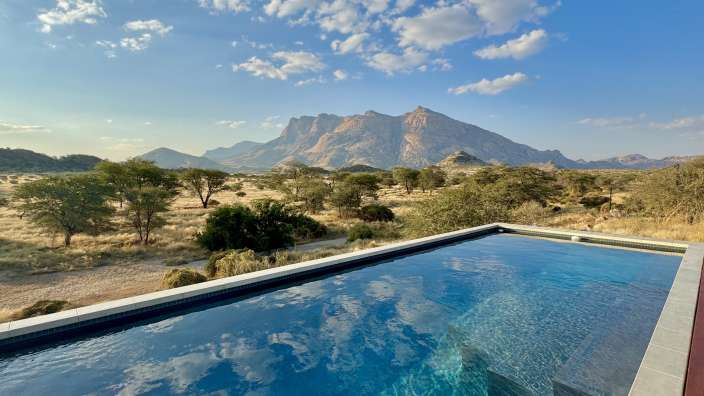 Ein Pool mit einem Berg im Hintergrund