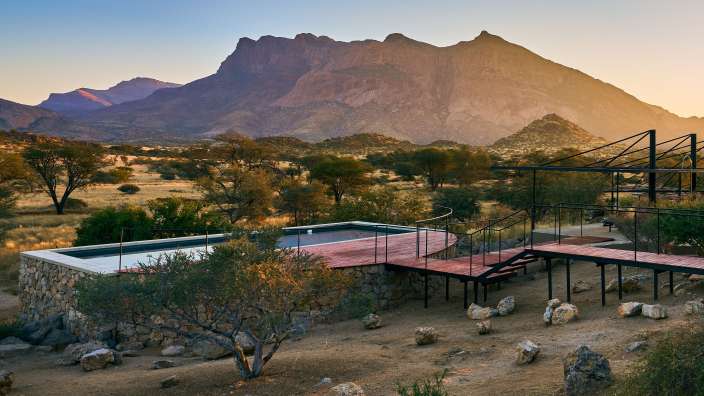 Ein Haus mit einem Pool und einem Berg im Hintergrund