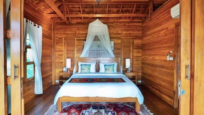 Ein Holzzimmer mit einem Bett und einem Teppich