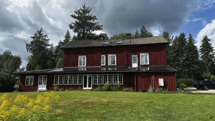 Ein großes rotes Holzhaus mit vielen Fenstern
