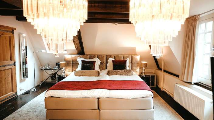 Ein Schlafzimmer mit einem Bett und zwei Kronleuchtern