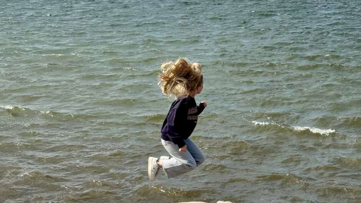 Ein kleines Mädchen springt ins Meer