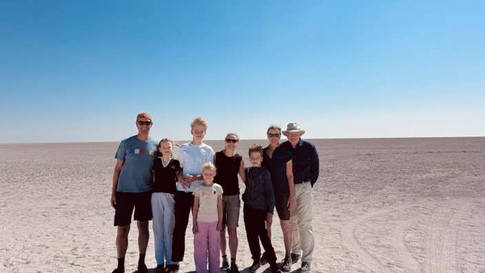 Eine Gruppe von Menschen steht auf einem sandigen Strand