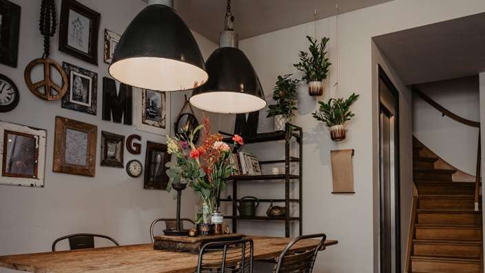 Ein Esszimmer mit einem Tisch und Stühlen und Bildern an der Wand