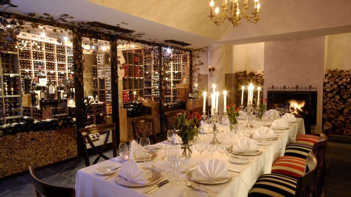 Ein langer Tisch in einem Restaurant mit Kerzen und einem Kamin