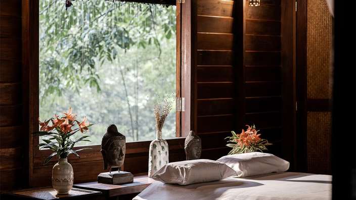 Ein Schlafzimmer mit einem Bett und einer Vase mit Blumen darauf