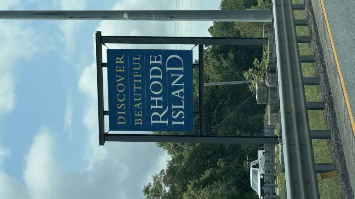 Ein blaues Schild mit der Aufschrift " Entdecken Sie die schöne rhode island "