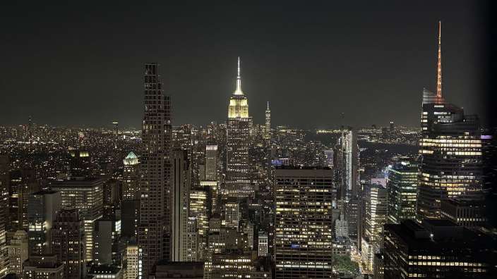 Die skyline von new york city bei nacht mit dem empire state building im hintergrund