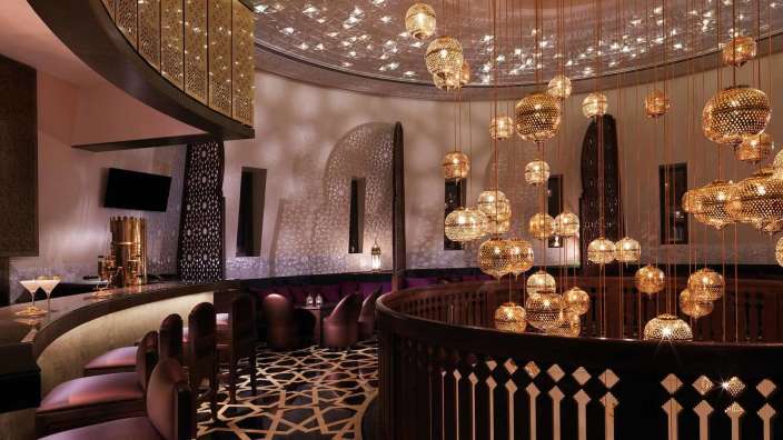 Eine Bar mit vielen goldenen Laternen an der Decke