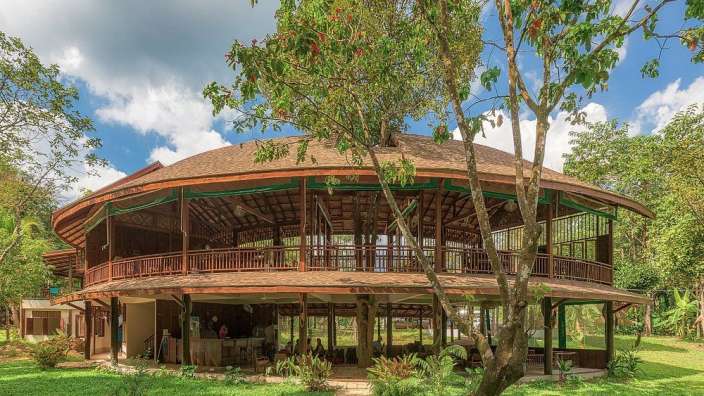 Ein rundes Holzhaus mit einem braunen Dach