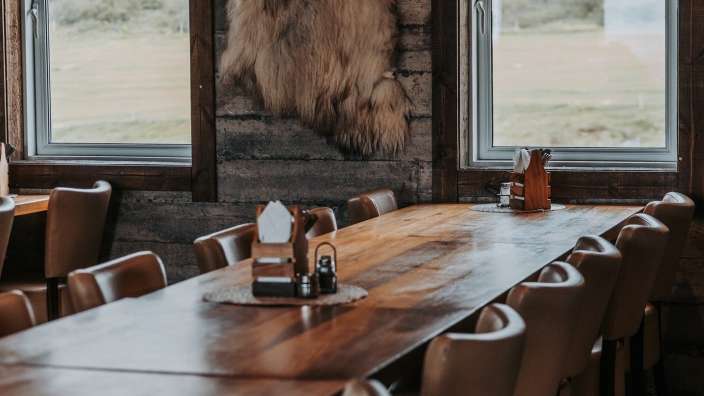 Ein langer Holztisch mit Stühlen in einem Restaurant