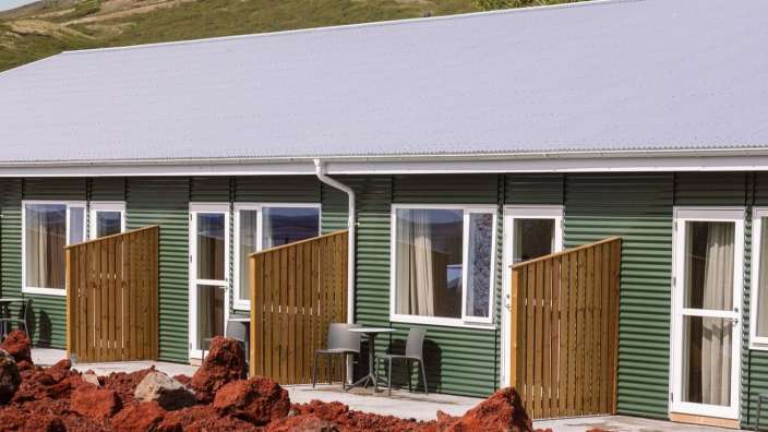 Eine Reihe grüner Häuser mit einem lila Dach