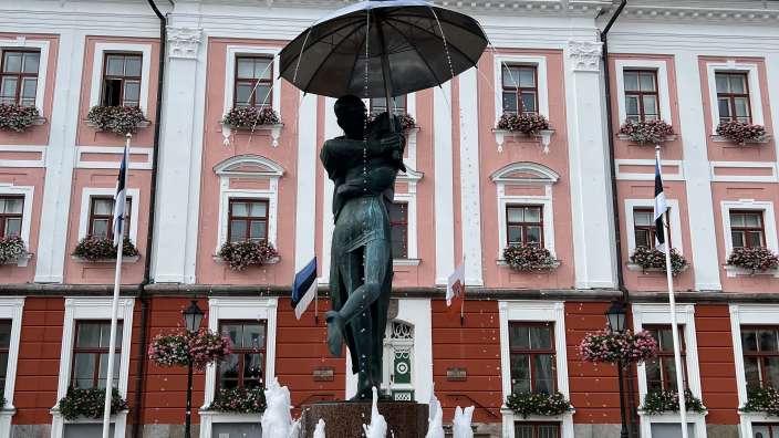 Ein Brunnen vor einem rosa und weißen Gebäude
