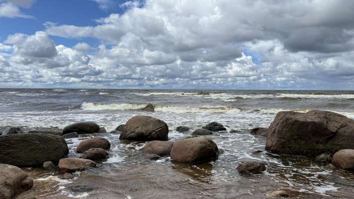 Ein Strand mit Felsen und Wellen an einem bewölkten Tag