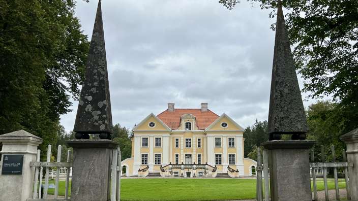 Ein großes gelbes und weißes Gebäude mit einem roten Dach