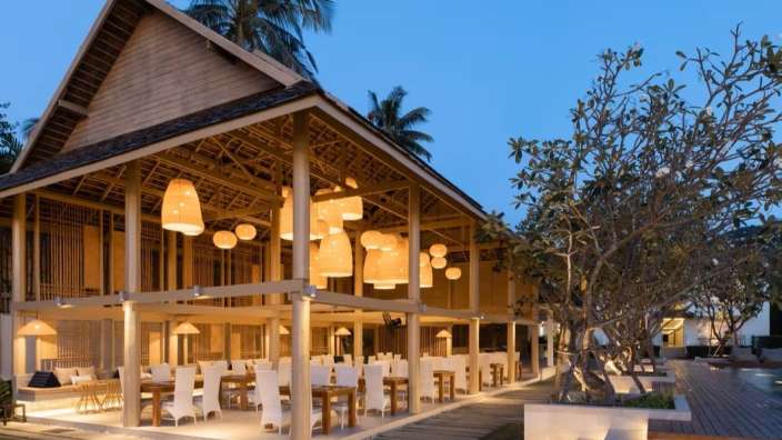 Ein großes hölzernes Gebäude mit vielen Tischen und Stühlen