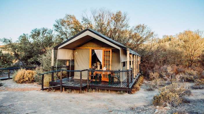Ein Zelt mit einem Tisch und Stühlen auf der Veranda