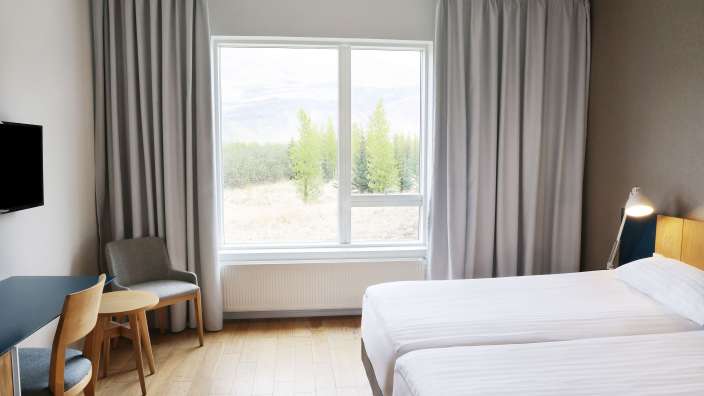 Ein Hotelzimmer mit zwei Betten und einem Fernseher