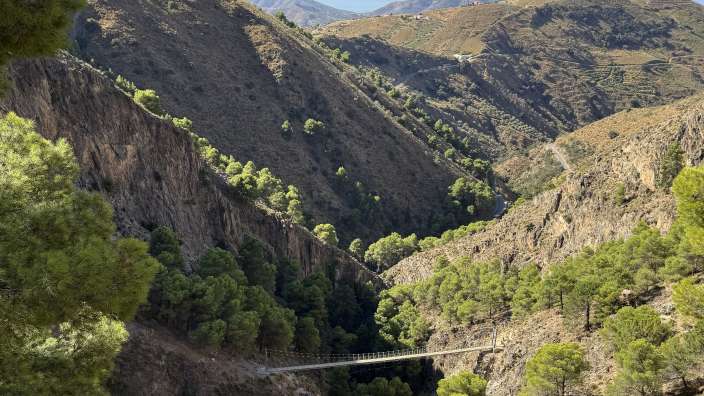 Wanderung Aceituno nach El Saltillo Eine Hängebrücke über einen Fluss zwischen zwei Bergen