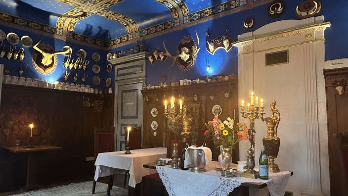 Ein Speisesaal mit einem blauen Decke und einem Tisch mit Kerzen darauf