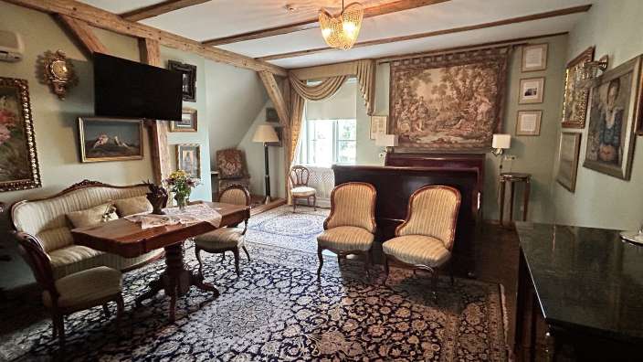 Ein Wohnzimmer mit einem Tisch und Stühlen und einem Fernseher