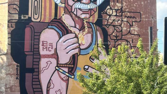 Eine Wandmalerei eines alten Mannes mit Bart und Sonnenbrille