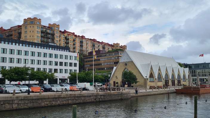 Ein Gebäude mit einem weißen Dach steht neben einem Fluss