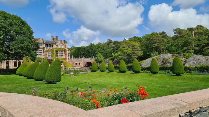 Ein Garten mit einem großen Gebäude im Hintergrund
