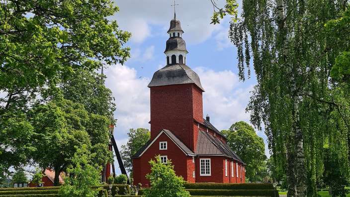 Ein Friedhof mit einer roten Kirche im Hintergrund