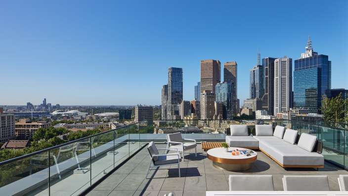 Ein Balkon mit einer Couch und Stühlen und einem Tisch
