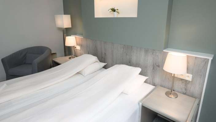 Ein Hotelzimmer mit einem Bett und zwei Lampen