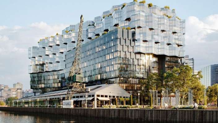 Ein großes Gebäude mit vielen Fenstern steht neben einem Fluss