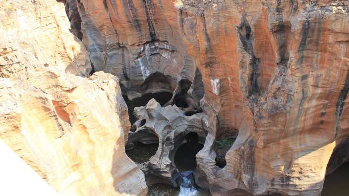 Ein Wasserfall stürzt aus einer Felswand in einen Fluss