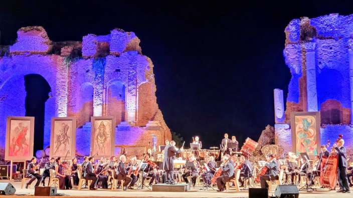 Konzert im Teatro Greco in Taormina Ein Orchester spielt vor einem ruinierten Gebäude