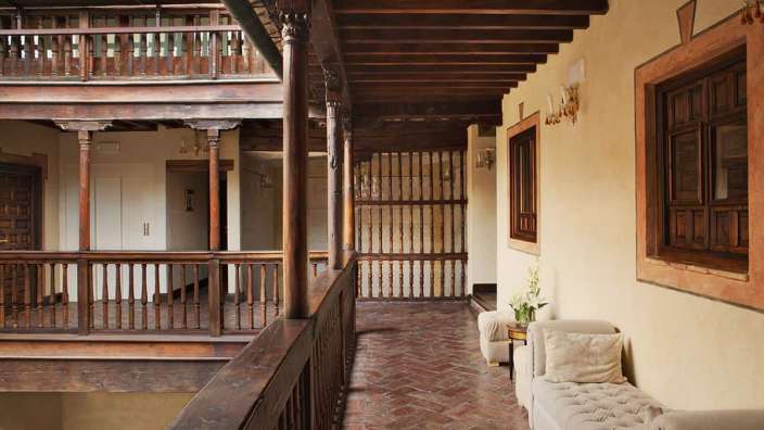 Ein langer Flur mit einem Holzgeländer und einer Couch