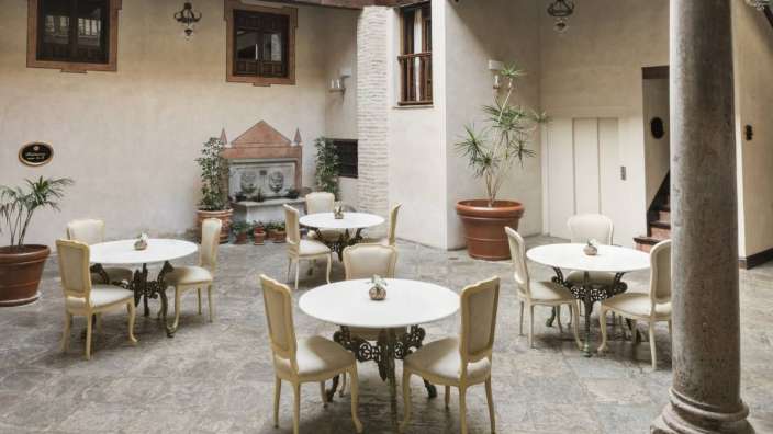 Ein kleiner Raum mit weißen Tischen und Stühlen