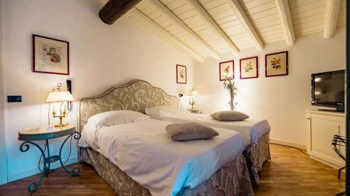 Ein schönes Zimmer mit zwei Betten und Gemälden an der Wand.
