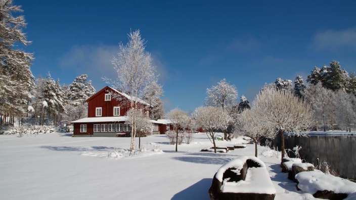 Rote Holzhäuser im weißen Schnee: stilvolles B&B bei Torsby