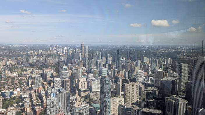 Blick von oben auf die Skyline von Toronto mit zahlreichen Wolkenkratzern und Gebäuden am hellen Tag.