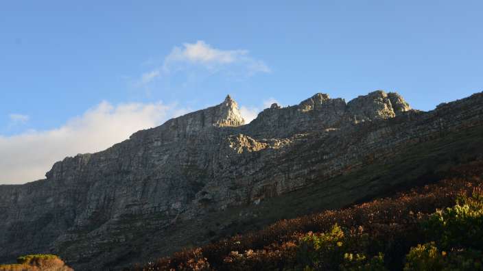 Nachmittagssonne beleuchtet den Tafelberg mit Maclear’s Beacon und den Hangehängen in Kapstadt.