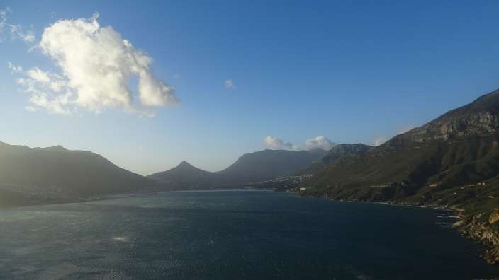 Blick auf Hout Bay und die umliegenden Berge auf der Kap-Halbinsel an einem sonnigen Tag.