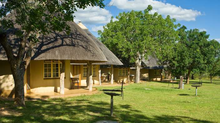 Eine Gruppe von Hütten mit Strohdach stehen nebeneinander