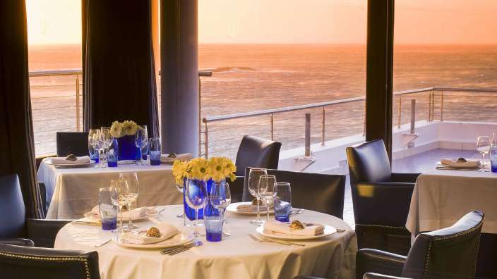 Tische und Stühle in einem Restaurant mit Blick auf das Meer