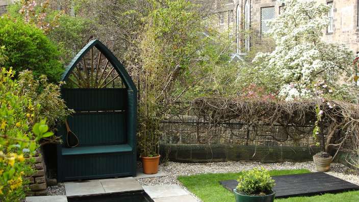 Ein Garten mit einer Bank und einem Teich