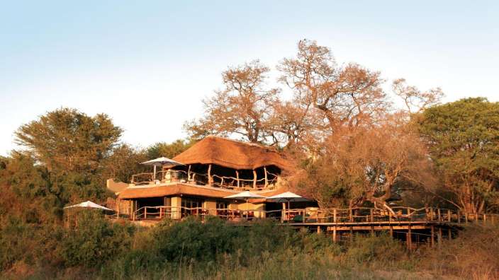 Ein großes Haus mit Strohdach sitzt auf einem Hügel