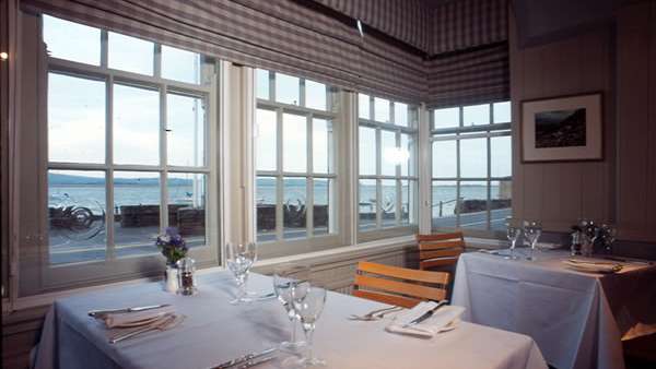 Ein Tisch mit weißem Tischtuch und Gläsern auf einem Restaurant