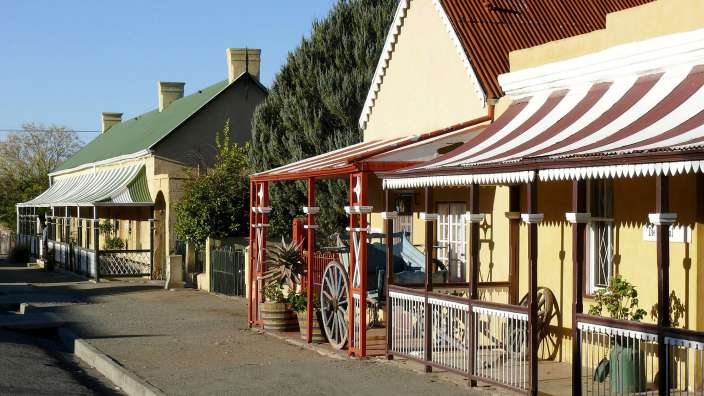 Eine Reihe von Häusern mit roten und weißen Vorhängen