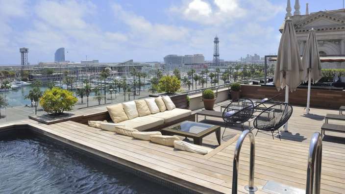 Eine Terrasse mit einem Swimmingpool und einer Couch